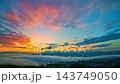 A cinematic drone aerial view of sunrise casting warm golden light over a misty mountain valley. Layers of fog drift between forested hills while distant peaks glow beneath a colorful dawn sky, creati A cinematic drone aerial view of sunrise casting warm golden light over a misty mountain valley. Layers of fog drift between forested hills while distant peaks glow beneath a colorful dawn sky, creati 143749050