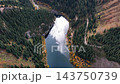 Aerial view of Lake Kaindy and the coniferous ridges, reflecting silvery light. 143750739