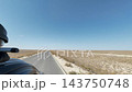 In-car forward-facing footage of a paved road stretching straight to the horizon across the plains of Mangystau. 143750748