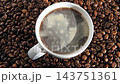 Pouring black coffee into white ceramic cup. Top view. Close up. Hot coffee drink pour into cup from shiny moka pot coffee maker. Roasted coffee beans background. Freshly brewed Espresso, americano. 143751361