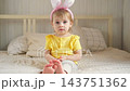 Portrait of adorable baby girl with bunny ears. Cute funny girl celebrating Easter at home. Surprised little kid. Spring. Traditional symbol of holiday and religion concept. Happy Easter. Easter child 143751362
