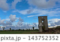 Daylight timelapse of fast moving cumulus clouds forming in a blue sky over an ancient ruined stone estate tower in Denia, Spain. 143752352