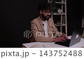 Focused male freelancer typing on laptop computer at desk 143752488