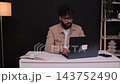 Focused millennial businessman talking on phone working on laptop 143752490