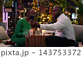 Romantic couple using smartphone for video call during date night out in the city, greeting someone and having conversation. Man and woman having dinner at rooftop restaurant and doing phone call 143753372