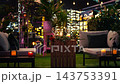 Roses resting next to wine glasses in romantic candlelit date setting. Flowers on rooftop restaurant terrace table prepared for intimate dinner reservation at night 143753391
