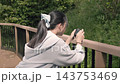 コンデジで写真を撮る日本人の少女の後ろ姿　趣味や課外活動で撮影を楽しむ様子 143753469