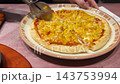 ピザカッターでトウモロコシピザを切る瞬間 143753994