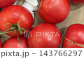 Ripe red tomatoes arranged closely on rustic cardboard, showcasing fresh produce, natural texture, green stems, and wholesome food styling for agricultural, culinary, grocery, and market themed video Ripe red tomatoes arranged closely on rustic cardboard, showcasing fresh produce, natural texture, green stems, and wholesome food styling for agricultural, culinary, grocery, and market themed video 143766297