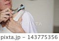 Dog refusing teeth brushing and turning head away from toothbrush 143775356
