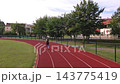 Woman jogging on running track at outdoor stadium 143775419