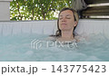 Woman relaxing with water massage in hot tub 143775423