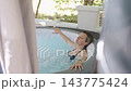 Woman relaxing with hydromassage in outdoor hot tub 143775424