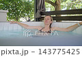 Woman sitting in an inflatable hot tub and resting in water 143775425