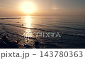 Calm sunset at Baltic sea, seascape with wooden breakwaters, nobody 143780363