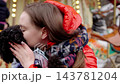 Woman enjoys cuddling her furry friend at a festive outdoor location 143781204