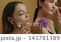 Women practicing skincare routines with floral decorations in a relaxing setting 143781389