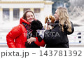 Friends enjoy a playful moment with dogs in a city park 143781392