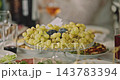 Green Grapes and Banquet Dishes Arranged on a Festive Table 143783394