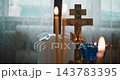 Orthodox Crucifix and Burning Prayer Candles Inside a Church 143783395