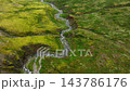 Rocky mountain stream flowing through mossy upland valley with small cascades under diffuse overcast light, river in Iceland 143786176