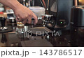 Barista Grinding Coffee Beans into Portafilter and Weighing on Scale 143786517