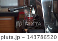 Espresso Shot Extraction into Clear Glass Cup Close Up 143786520
