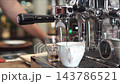 Barista Extracting Fresh Espresso Shot on Chrome Espresso Machine 143786521