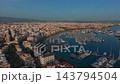 Palma De Mallorca Marina Fills Sheltered Harbor As Drone Glides Above Waterfront. Sailboats, Yachts, Dense Mediterranean Buildings And Mountain Horizon Define This Warm Evening View. 143794504