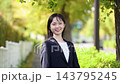 A young Japanese female employee, a recent graduate, smiles brightly in the beautiful autumn foliage outdoors, projecting a fresh image as a new employee. 143795245