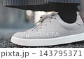 The feet of a person standing still in sneakers 143795371