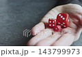 手のひらの上に乗せた赤いサイコロ 143799973