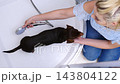 Woman washing her little dog in bath 143804122
