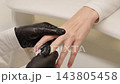 Manicurist Gently Massaging Fingers Of A Female Client After Professional Manicure At Beauty Salon. Relaxing Hand Care, Skin Moisturizing And Nail Aftercare. 143805458