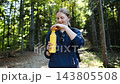 Woman hiker opening a yellow thermos bottle in forest 143805508