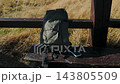 Hiking backpack and a smartphone on a wooden bench outdoors 143805509
