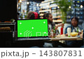 Isolated green screen mockup on laptop framed with rooftop party guests blurred behind, providing screen replacement and chroma key on device during BBQ event. 143807831