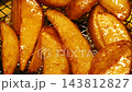 Close-up slow motion fried crispy potato wedges deep frying in oil. French fries 143812827