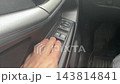 Closeup of driver operating window switches. Interior view of hand interacting with vehicle control buttons. Detailed shot of driver pressing electronic switches on door panel for convenience 143814841
