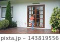 Child trick-or-treater approaches a home door 143819556