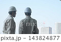A group of male workers looking out at a city under construction. (Keywords: construction, teamwork, safety, inspection, building, site, building maintenance, inspection) 143824877
