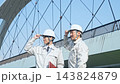 A group of male workers standing in front of a bridge. Infrastructure, construction, building, inspection, bridge, engineer, maintenance, contractor. 143824879