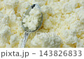 Fresh cottage cheese in a spoon with curd background close up 143826833