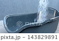 Pouring silica gel litter into a cat litter tray 143829891