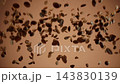 Roasted coffee beans flying up and scattering in slow motion on brown background 143830139