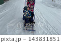 A woman carries her son and dog on a sled. 143831851