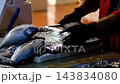 Fishmonger Cleaning Fresh Fish at a Traditional Fish Market. 143834080