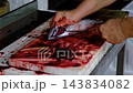 Fishmonger Cleaning Fresh Fish at a Traditional Fish Market. 143834082
