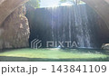 Wide view of Paleokarya artificial waterfall cascading into clear stream beneath old stone arch bridge in Pindus mountains near Trikala Thessaly Greece. 143841109