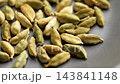 Green cardamom pods in kitchen bowl. Raw Indian spice. Macro shot. Rotation 143841148